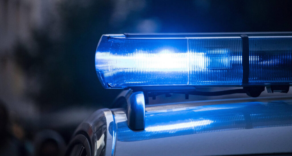 Blaues Polizeilicht auf dem Dach eines Polizeiautos in der Nacht